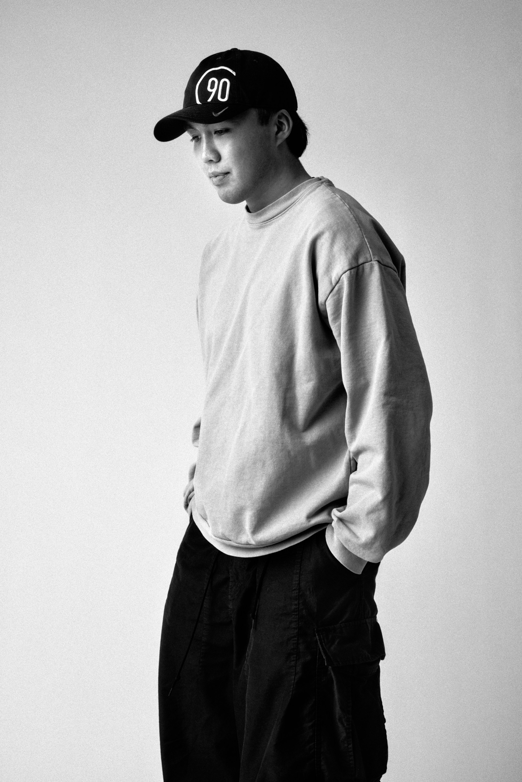 Black-and-white portrait of Sky Kawano wearing a 90 cap